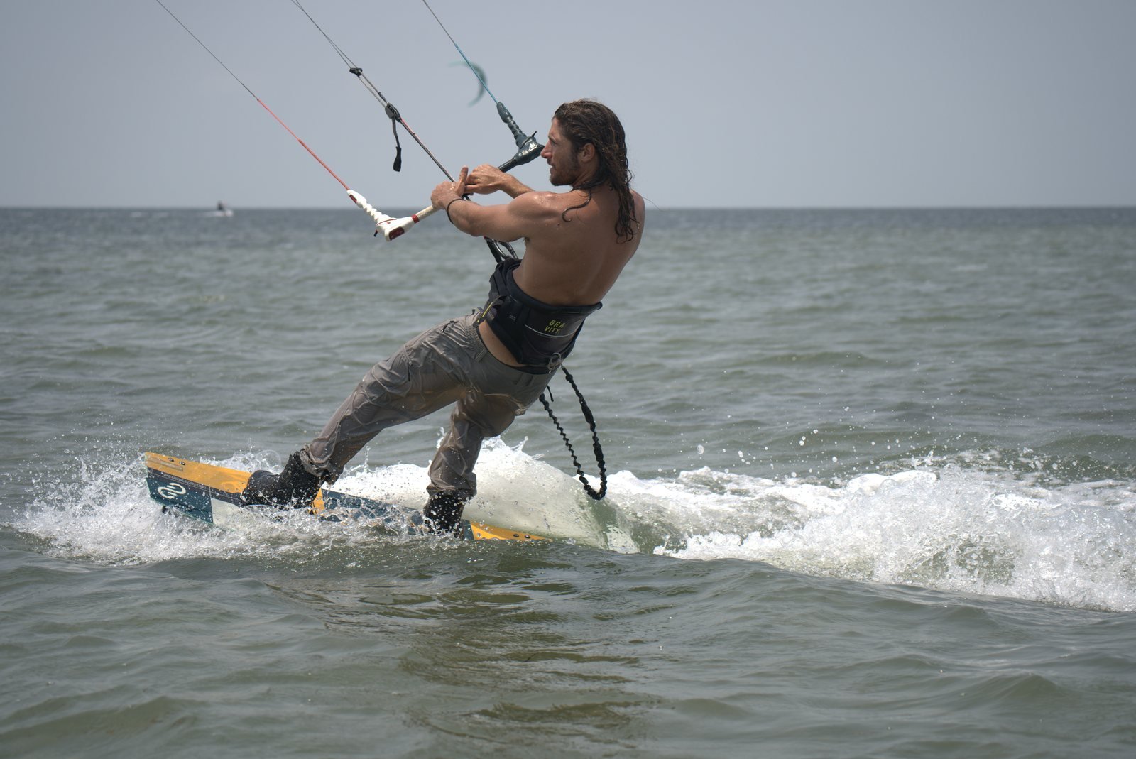 Kiteboarder carving through the water