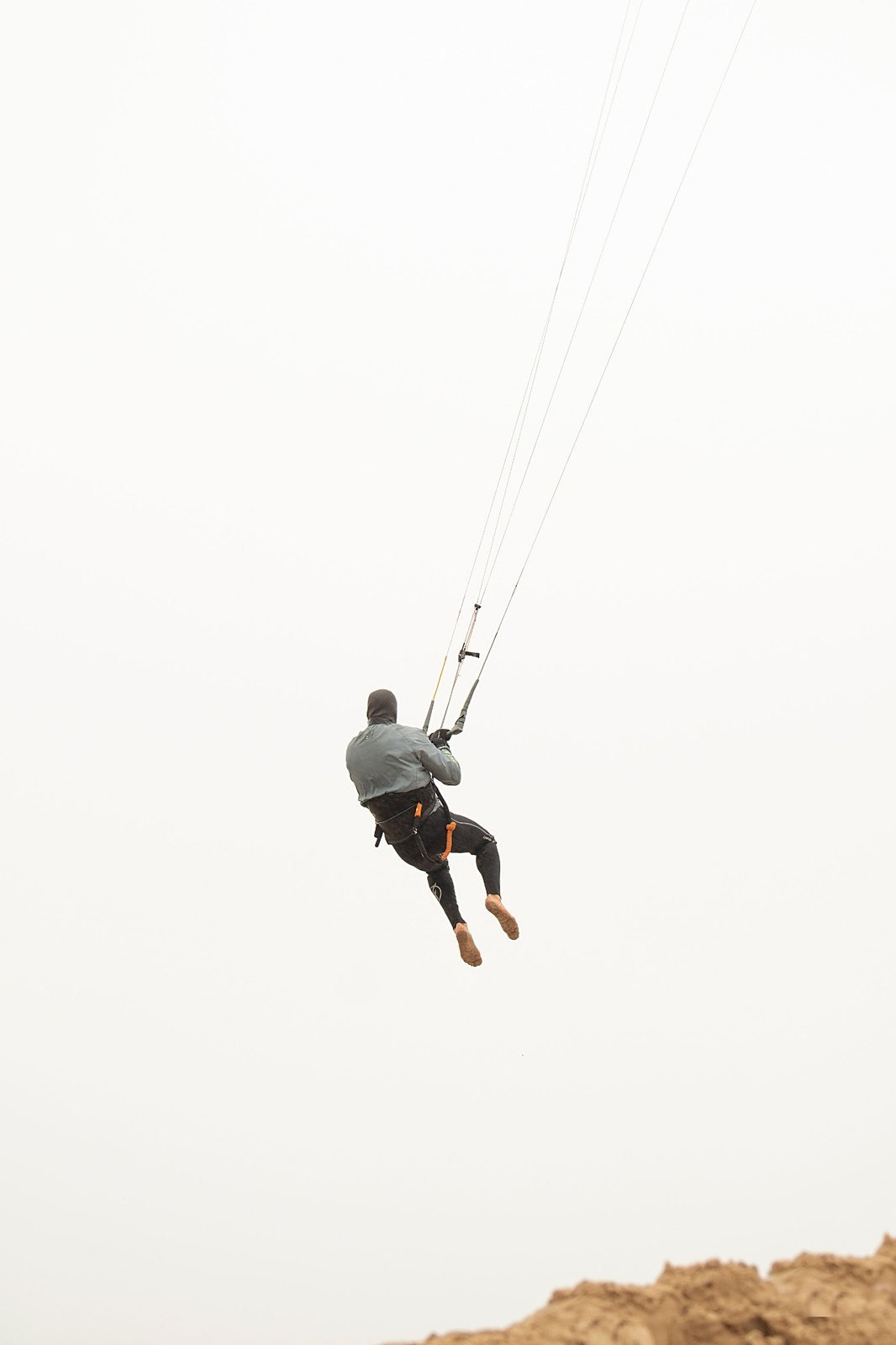 Kiteboarder jumping above a coastal beach