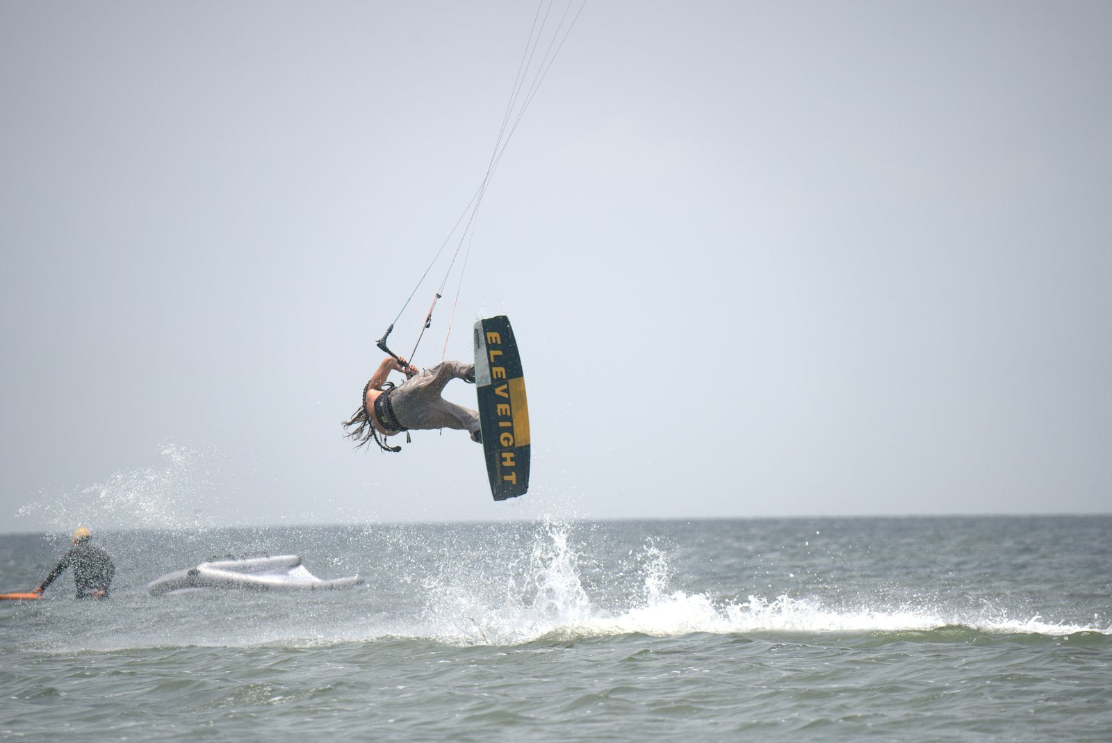 Kiteboarder performing an aerial trick above the waves