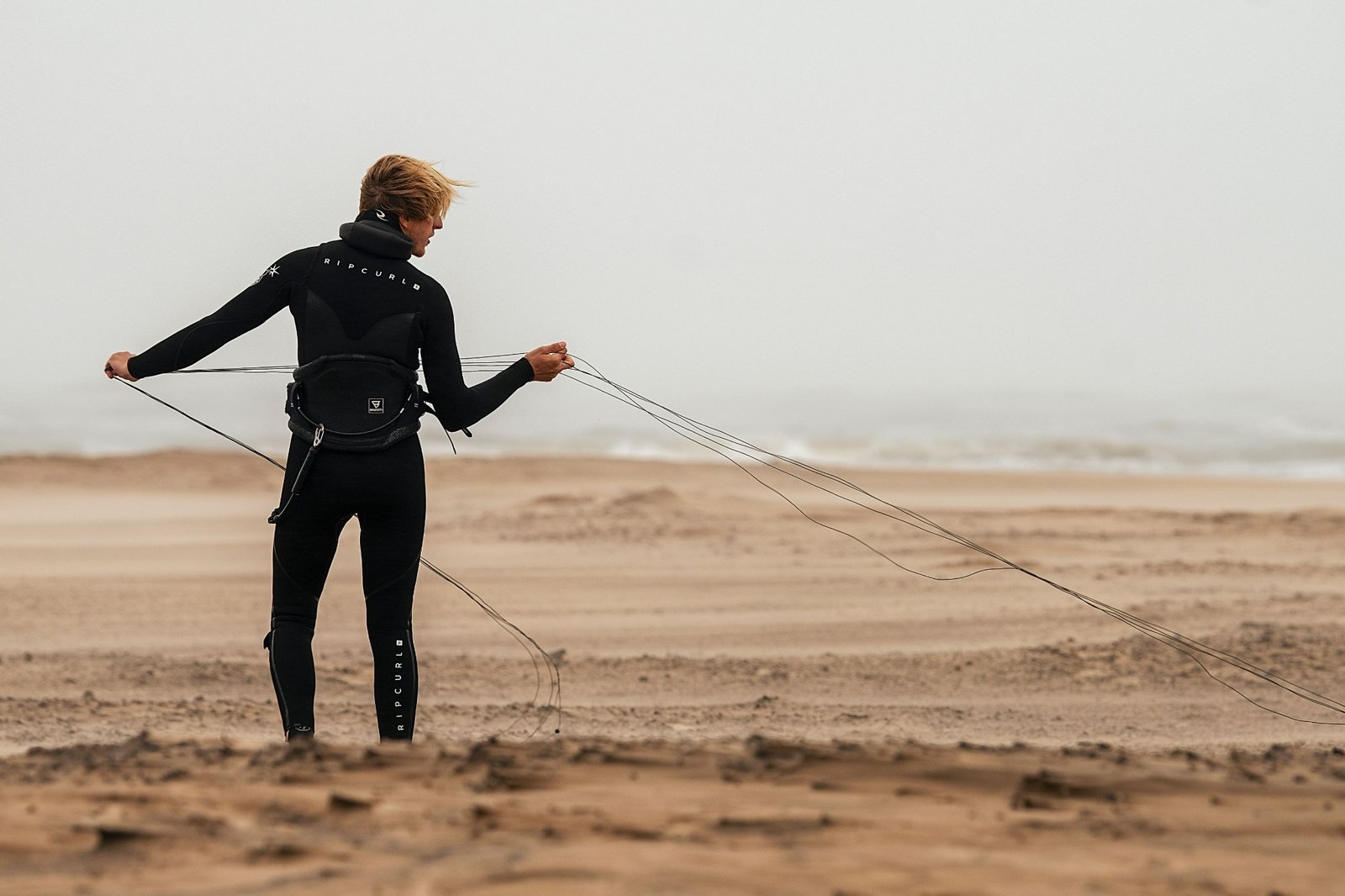 Kiteboarder preparing kite lines on the beach